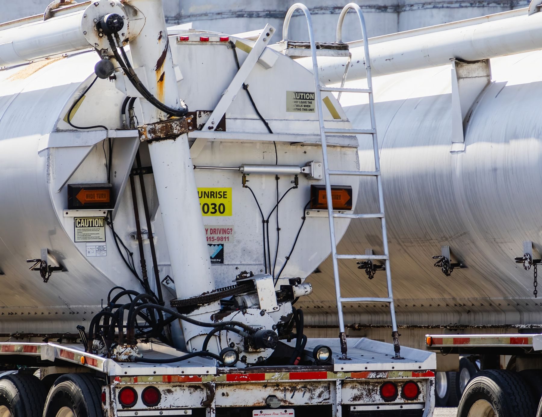 Tanker trailer valves, hoses and safety markings in close detail